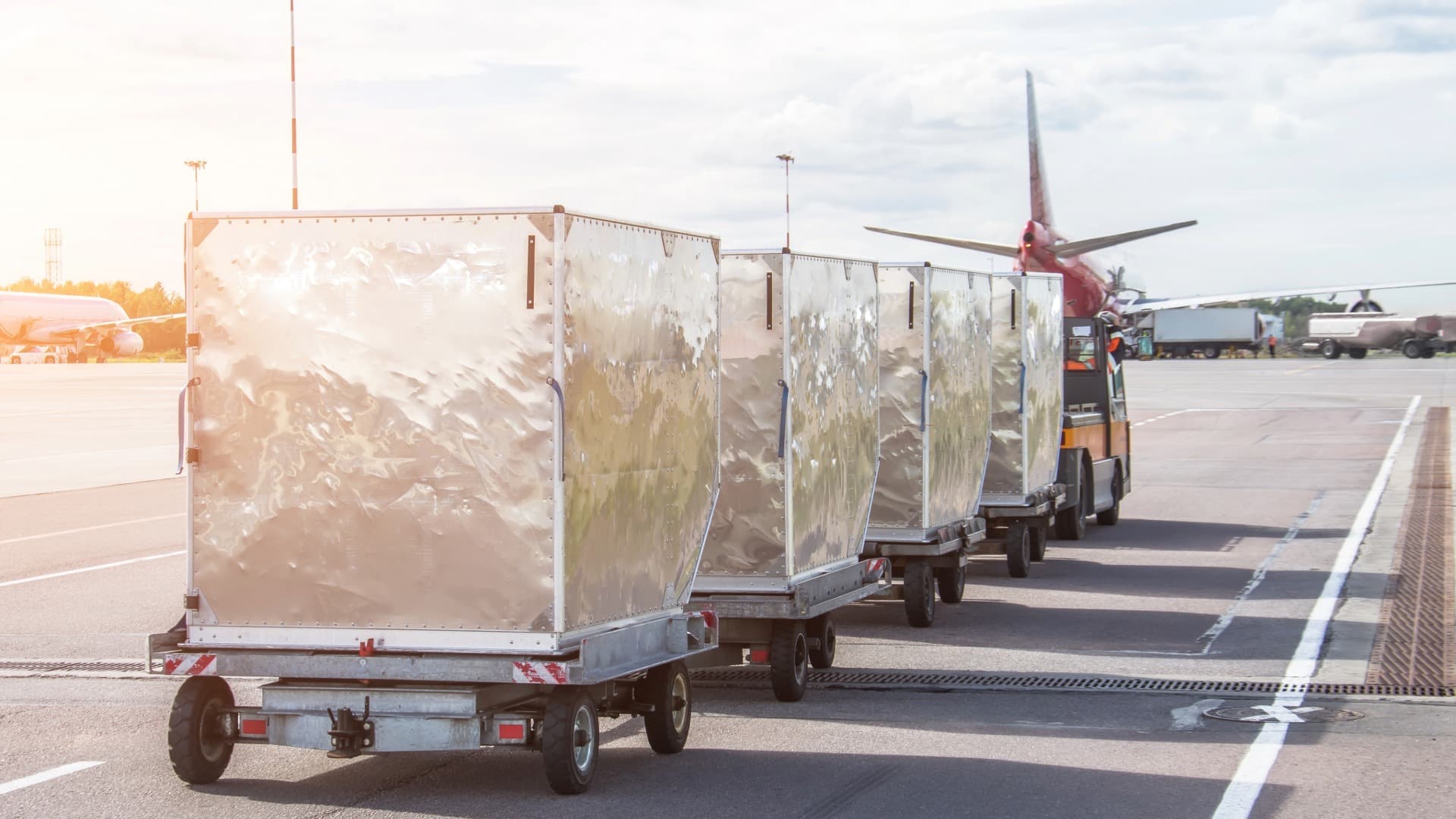 Air cargo containers on dollies on the airport apron – Air Chargeable Weight as the basis for freight costs