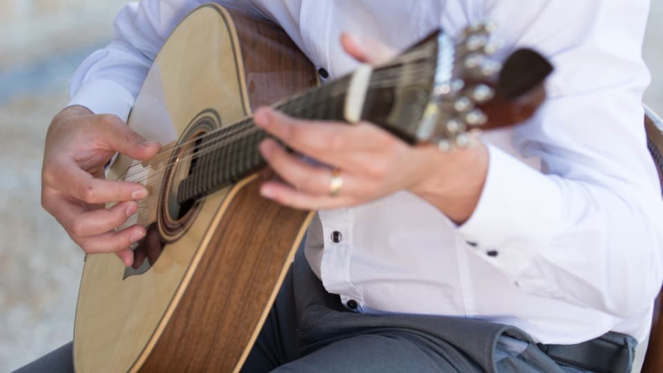 A Portuguese musician plays fado on a guitarra portuguesa