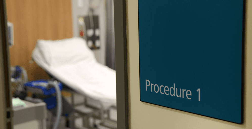 A view through a half-open door into a patient room at a hospital in New Zealand