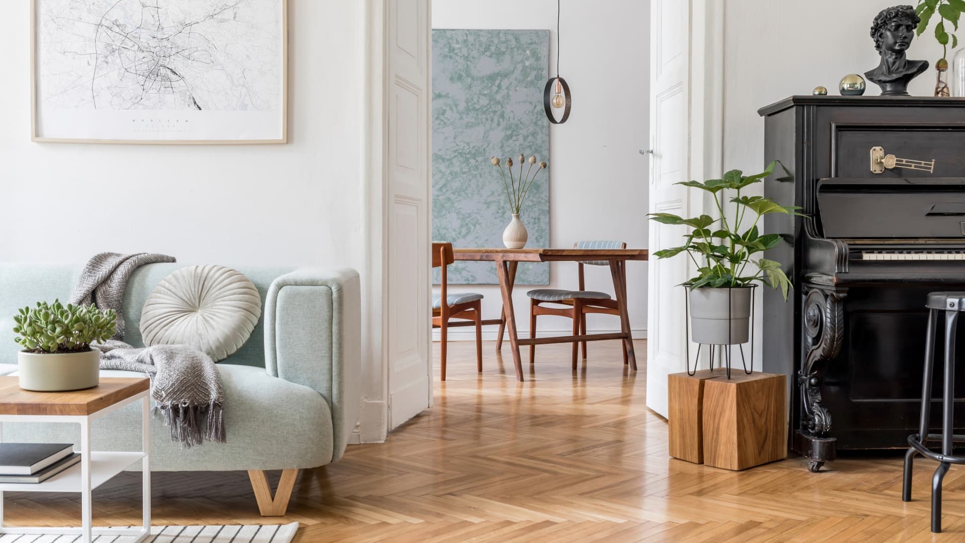 Bright living room with sofa, dining table and piano in a stylish apartment
