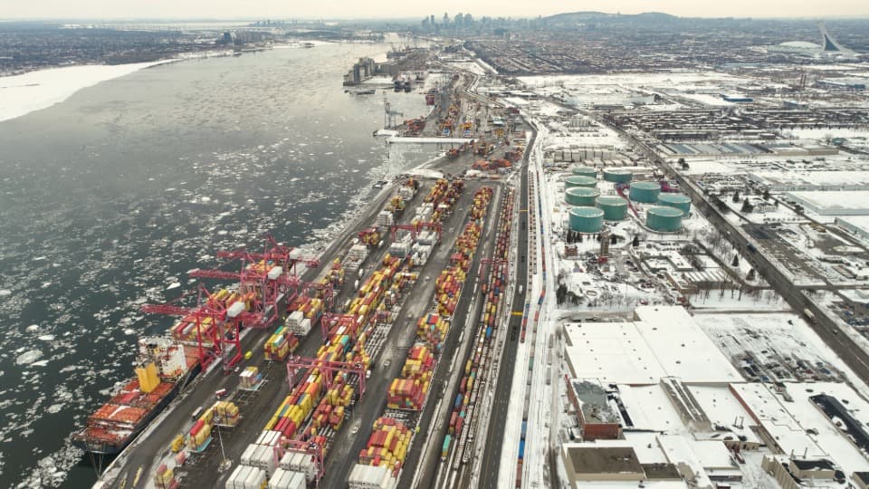 Snowy Port of Montreal with a cargo ship and railway tracks for inland transport during a move to Canada with DACHSER & KOLB.
