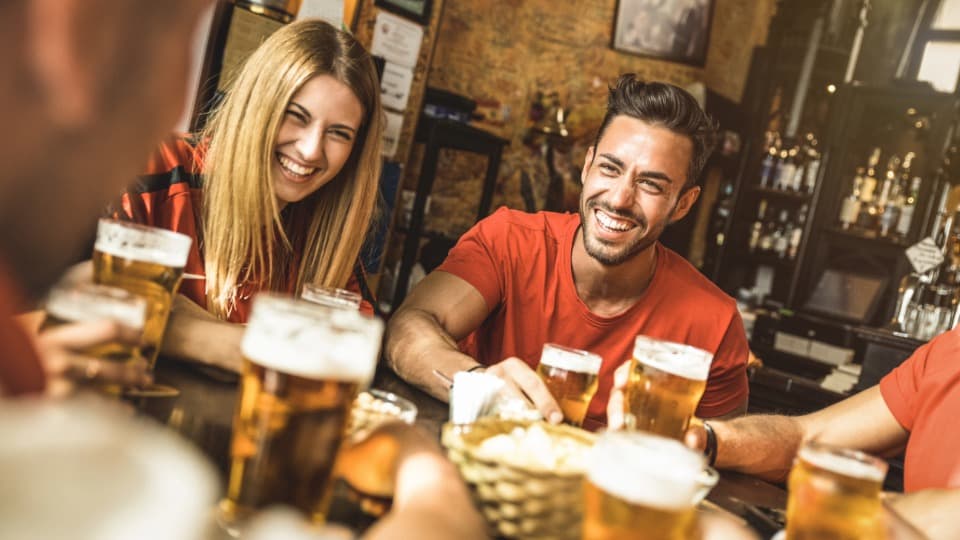 Friends in a British pub – pub culture as an essential place for social networking and integration in the UK.