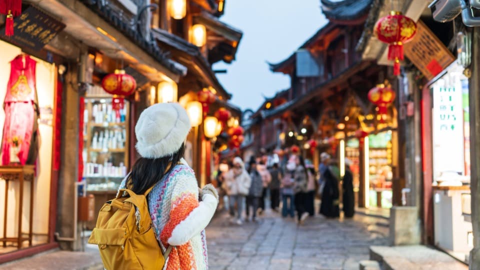 A woman is standing on a busy shopping street in China