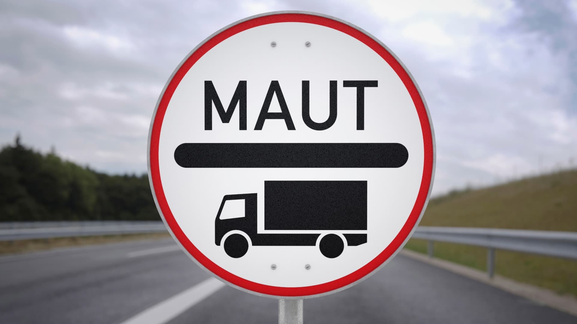 “MAUT” sign with truck icon by the road – indicating toll requirement on the highway