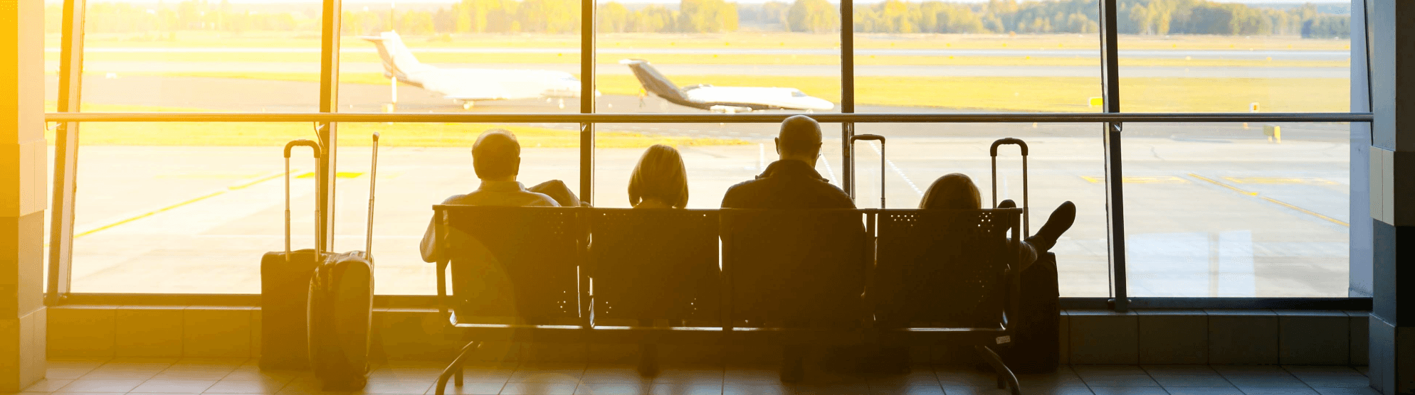 Travelers with luggage at the airport waiting for their flight – symbolic image for international relocation service