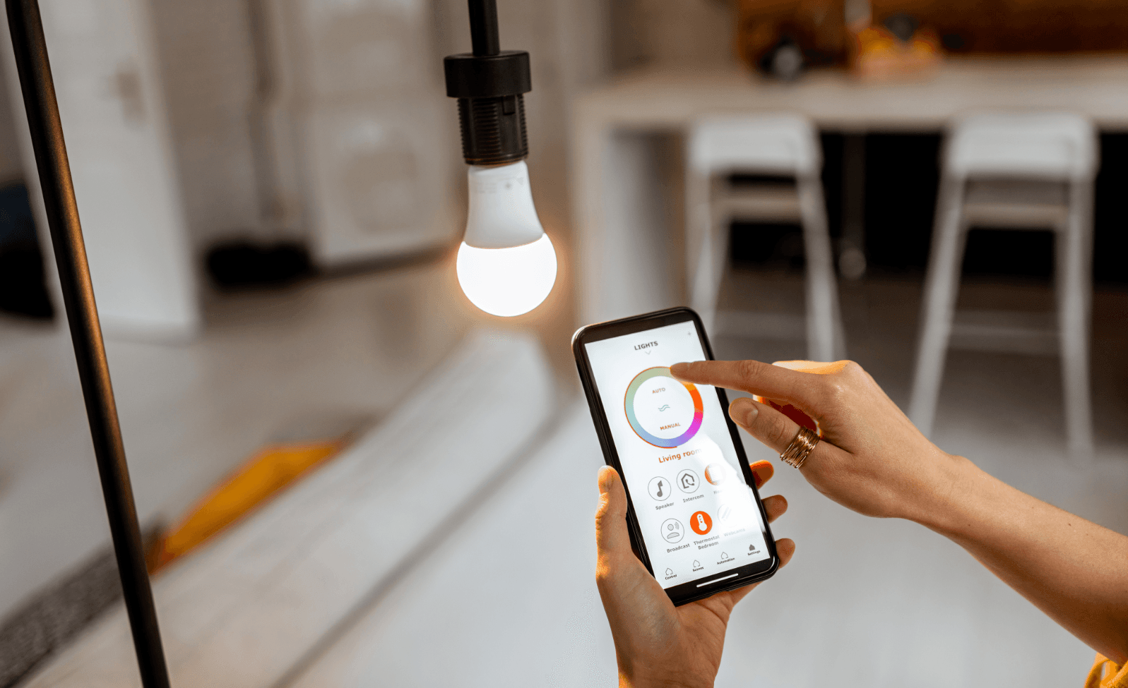 Smart home technology: person controls lighting via smartphone app for more comfort