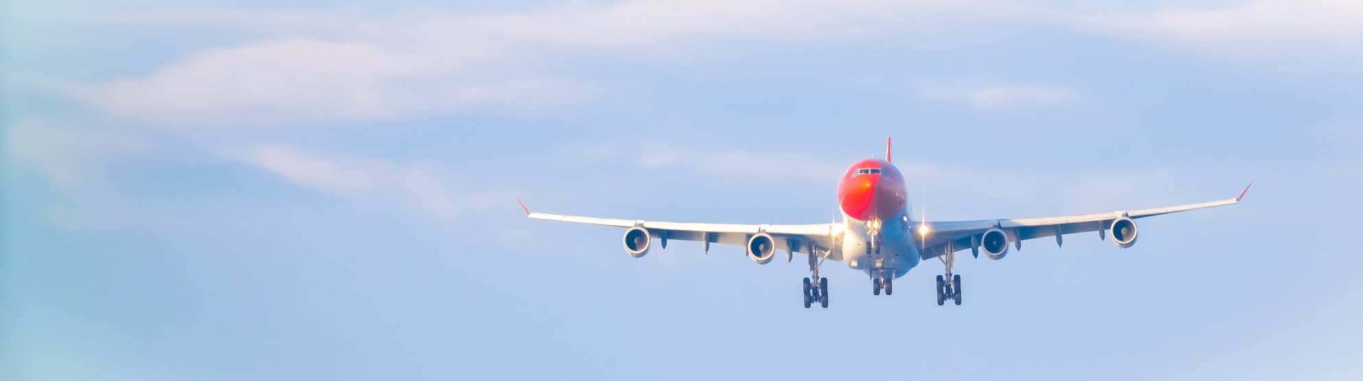 Airplane on approach against a blue sky, symbolic image for Thailand visa and entry
