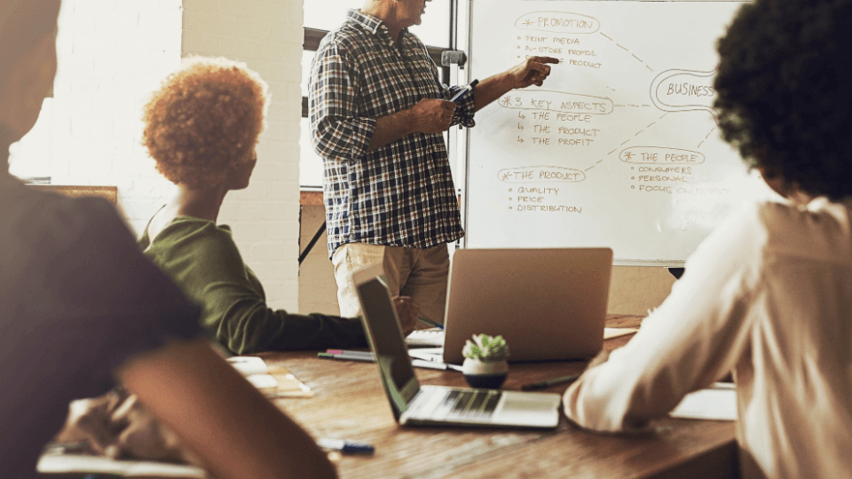 Team in a meeting with whiteboard – symbolic image for tips and knowledge in the moving ABC