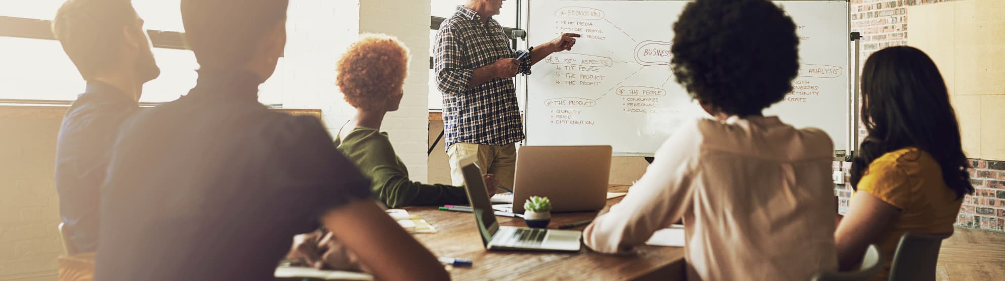 Team in a meeting with whiteboard – symbolic image for tips and knowledge in the moving ABC