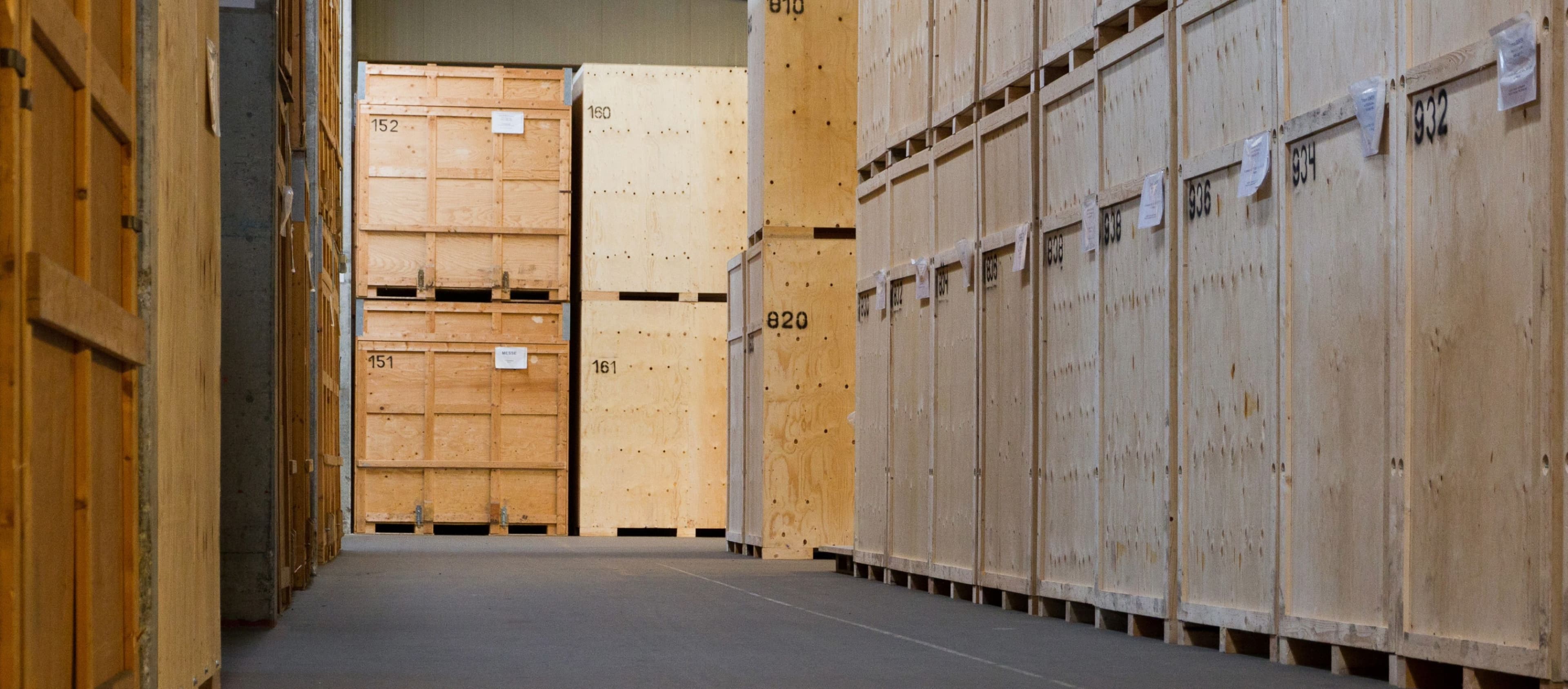 Row of numbered wooden crates in a secured moving storage facility for safe relocation storage.