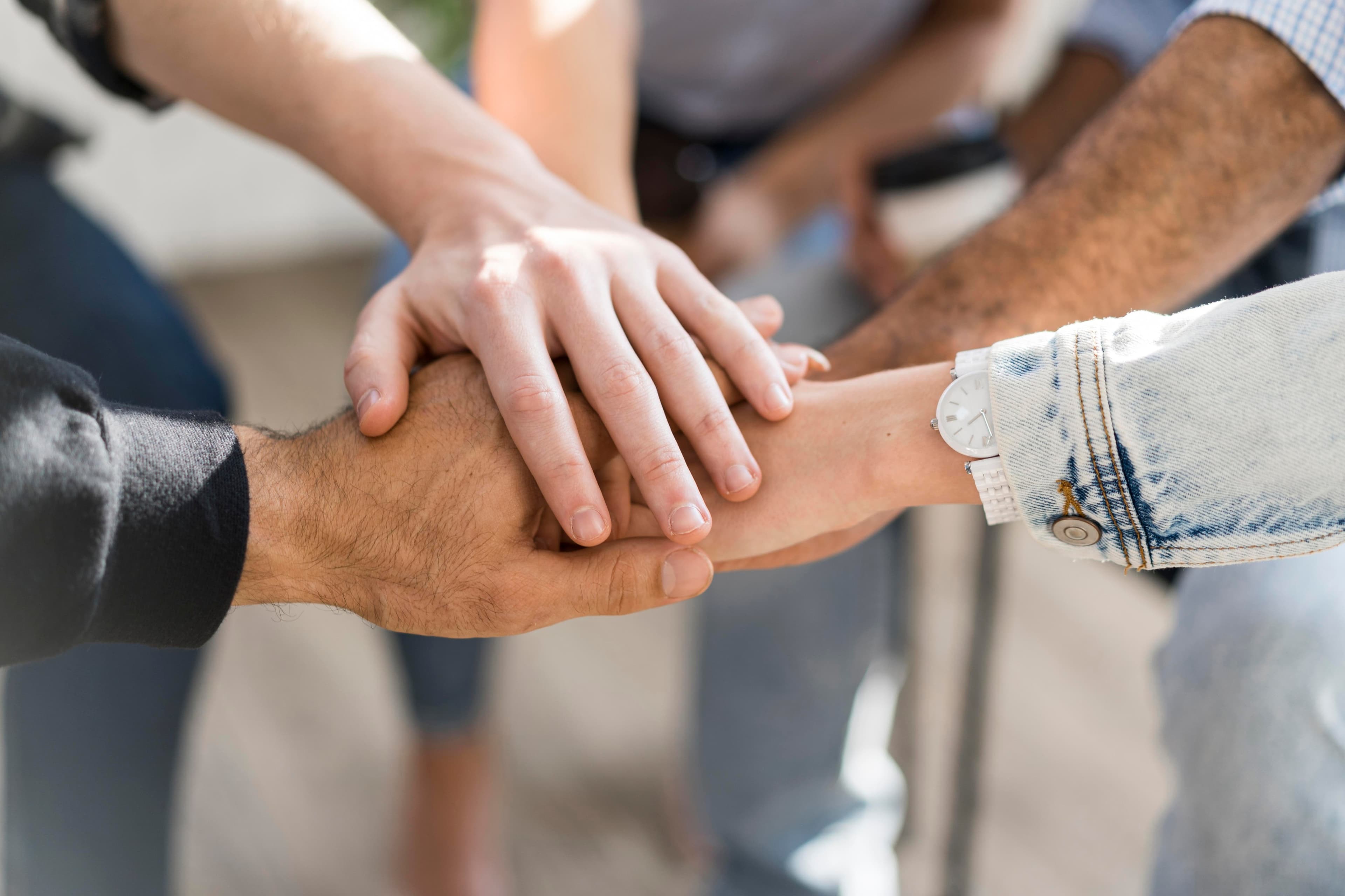 Stacked hands symbolizing collaboration in our partner network.
