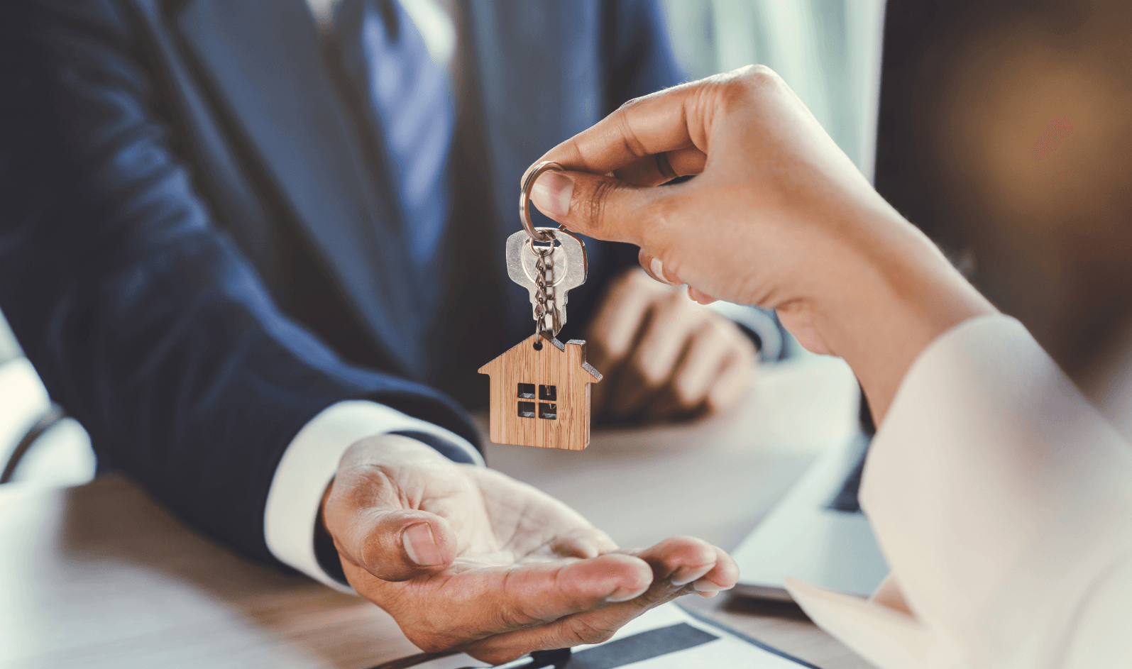 Handing over house key – symbolizes protection and insurance options for a residential move.