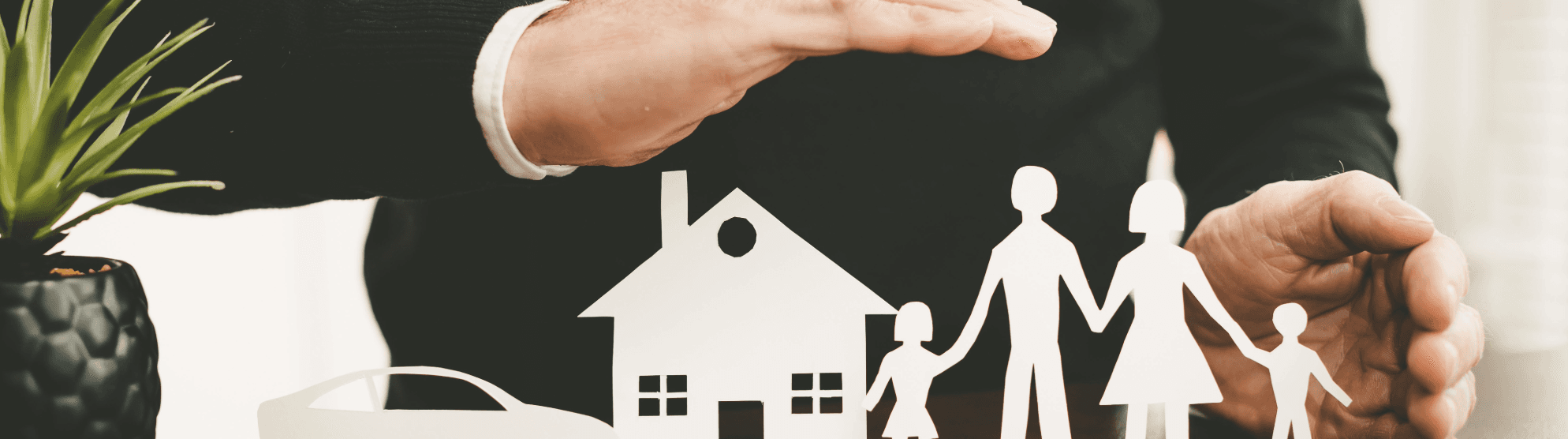 Protective hands over house, car and family – symbolic image for moving insurance options.