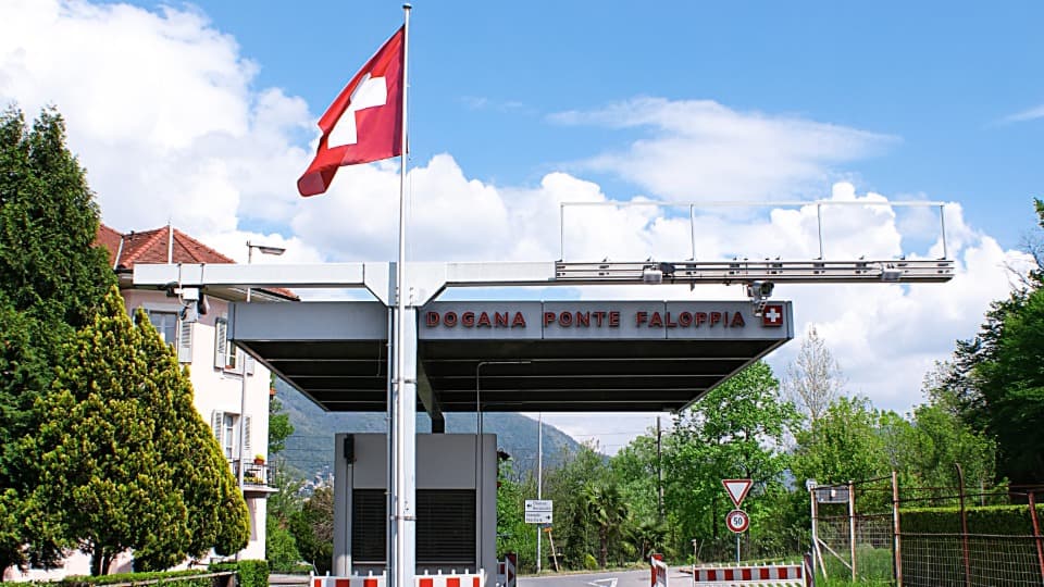 Swiss border crossing with customs checkpoint and Swiss flag in daylight