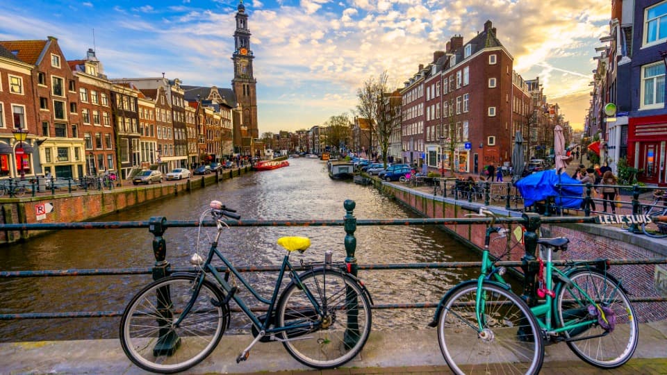 Bicycles on a bridge over a canal in Amsterdam at sunset