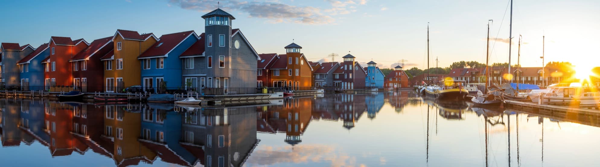 Colourful houses and boats along a canal in the Netherlands at calm evening light