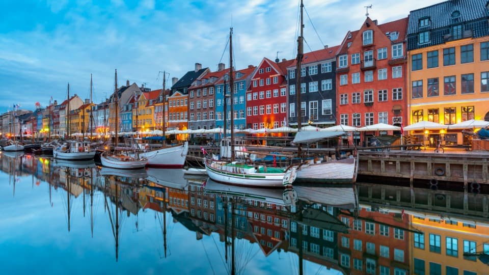 Colourful houses and boats at Nyhavn in Copenhagen as a symbol of everyday life in Denmark