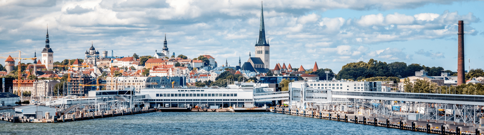 City view of Tallinn with harbour, old town and church spires under a cloudy sky