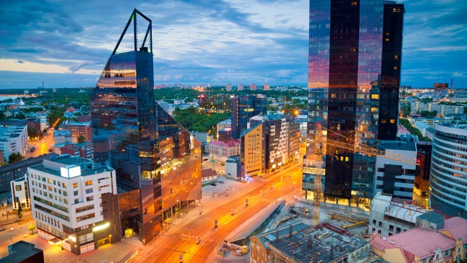 Modern high-rise buildings and illuminated street in central Tallinn at dusk