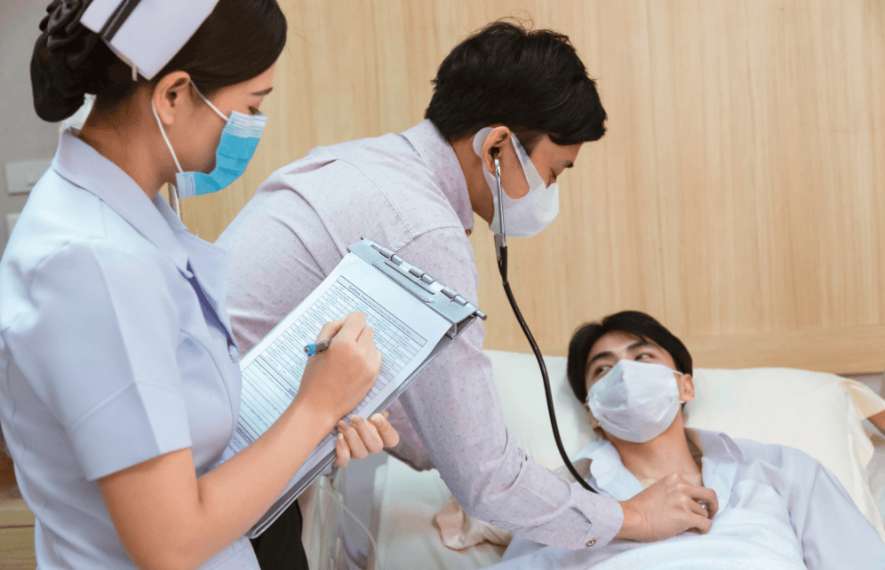 Doctor and nurse examine a patient in a hospital room
