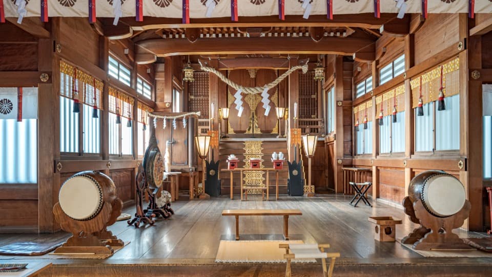 Interior of a traditional Japanese shrine with drums and wooden altar