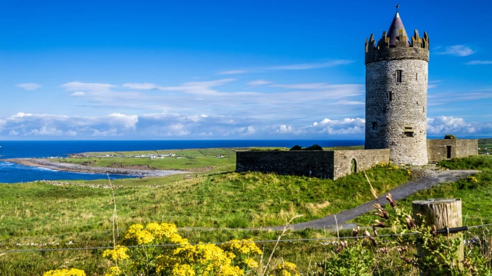 The historic Doonagore Castle on the Irish west coast, symbolizing the green landscape and nature in Ireland.