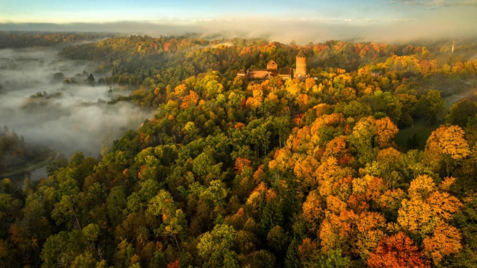 An autumnal aerial view of Turaida Castle in Gauja National Park – a symbol of the connection between history and unspoiled nature in Latvia.