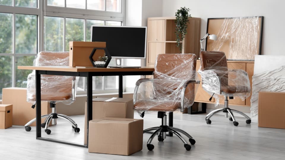 Wrapped office chairs and packed moving boxes during a professional site relocation and in-house logistics project with DACHSER & KOLB.