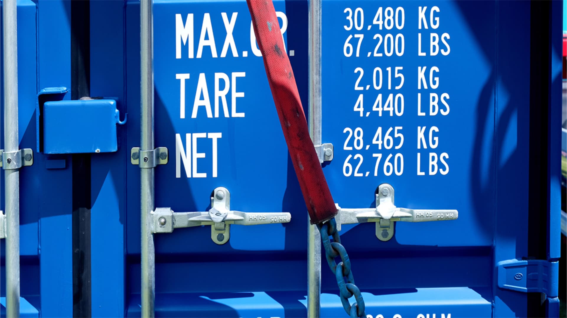 Close-up of a blue freight container's markings with weight specifications, highlighting the relevance of volumetric weight in global shipping.