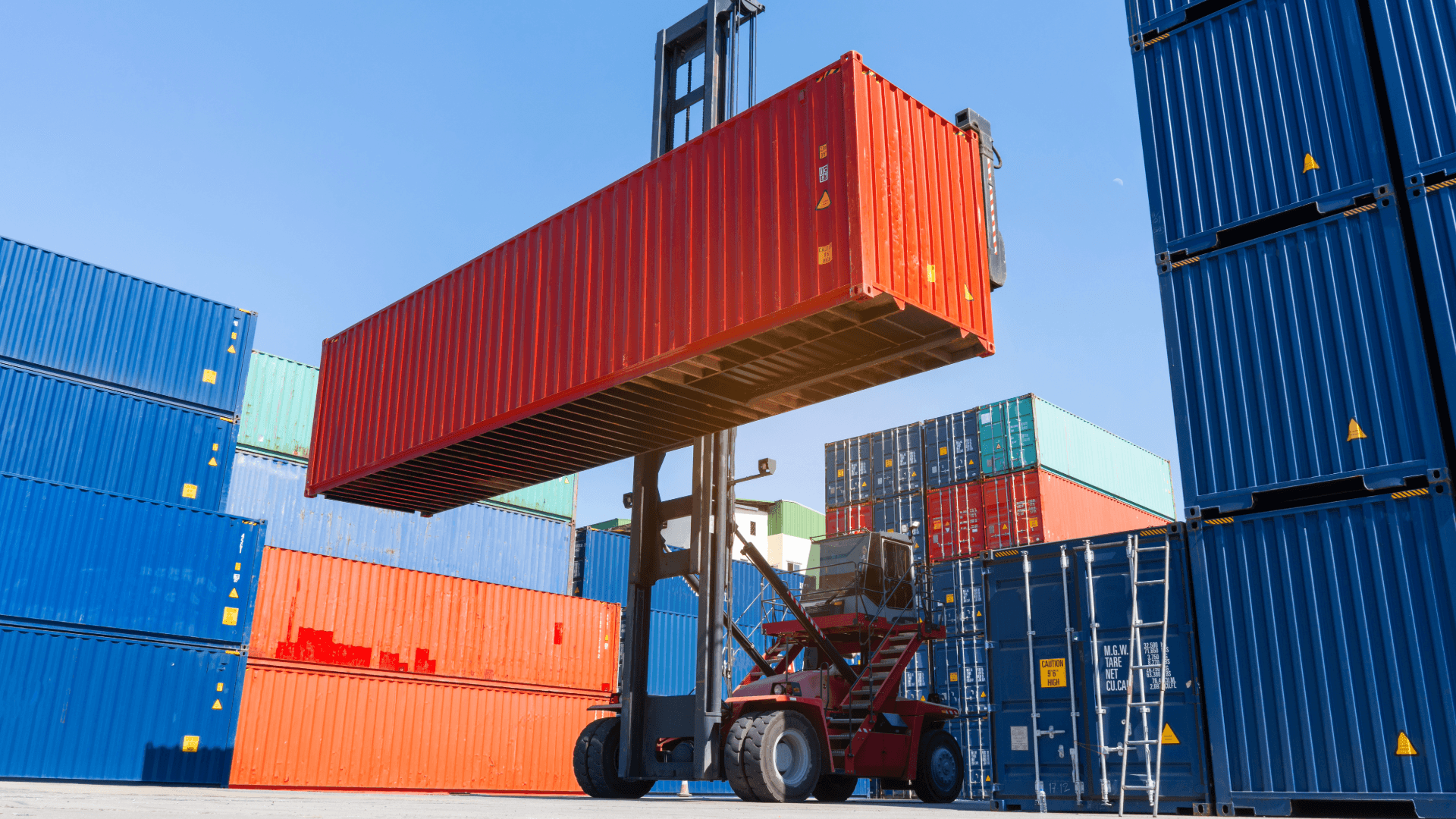 Forklift lifting a red shipping container. Various container sizes in the background. Logistics and transport.