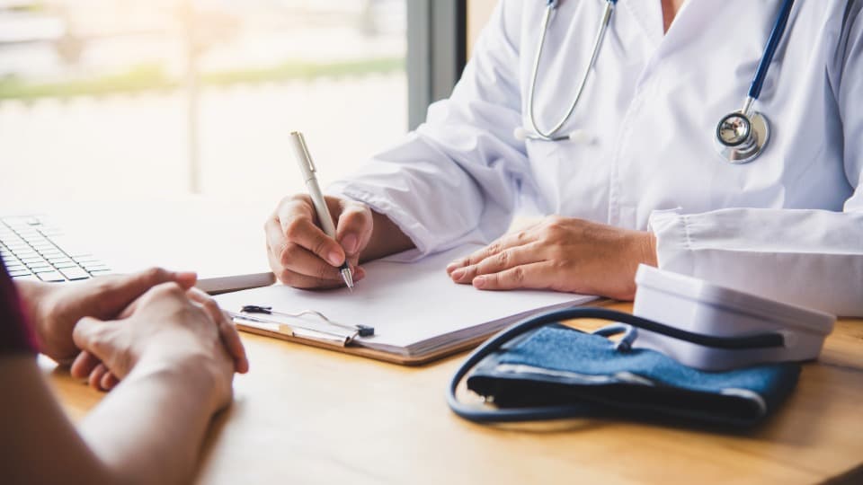 A doctor from Israel is talking to a patient and taking notes