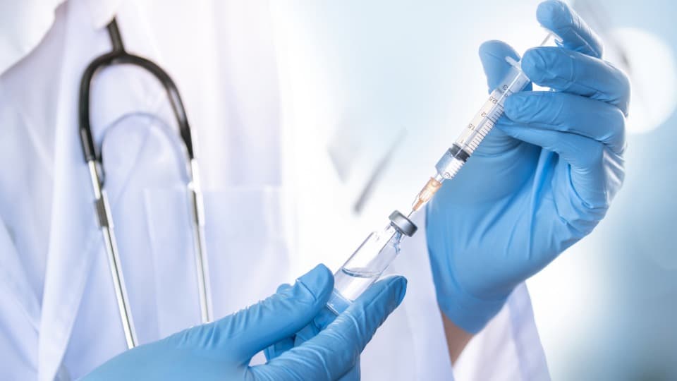 A doctor from Indonesia draws up a syringe with medication