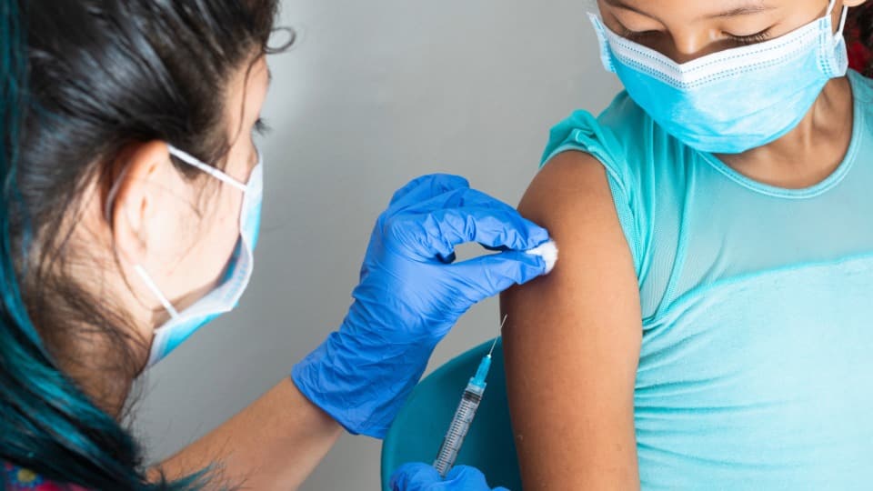 A Colombian doctor vaccinates a child – the healthcare system in Colombia