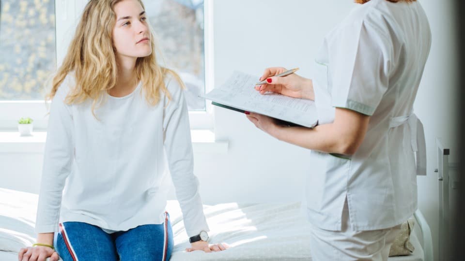 During her daily rounds, a doctor discusses the patient's current health metrics with a Swedish patient