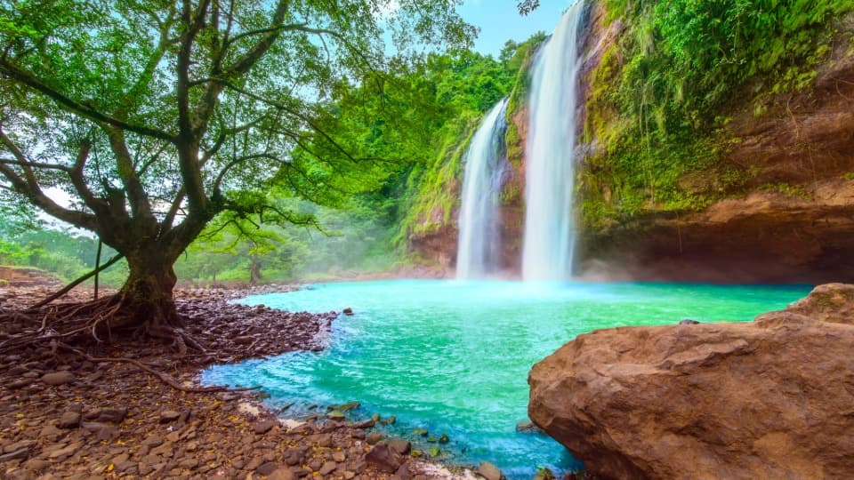 A lake in Indonesia with waterfalls and tropical forests