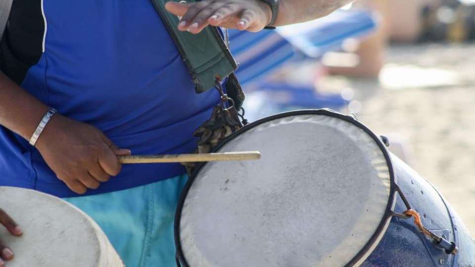A person is playing the candombe drum