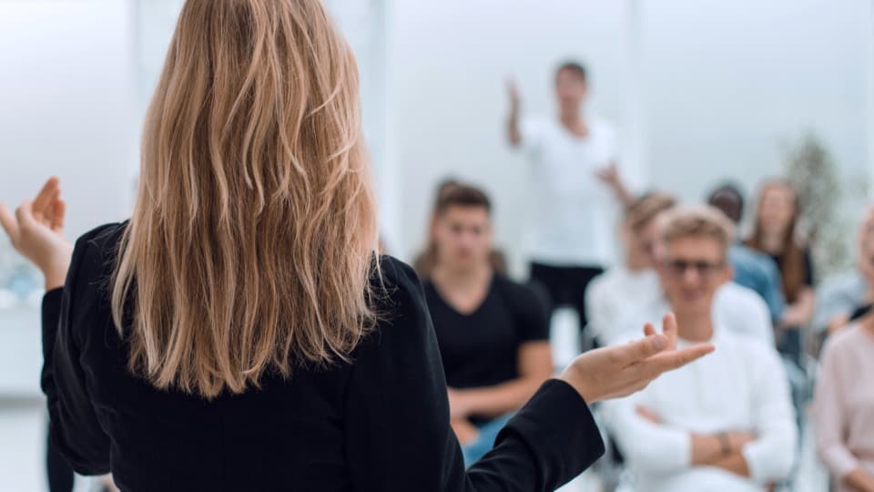 A presenter gives a talk to employees to prepare them for the office relocation.