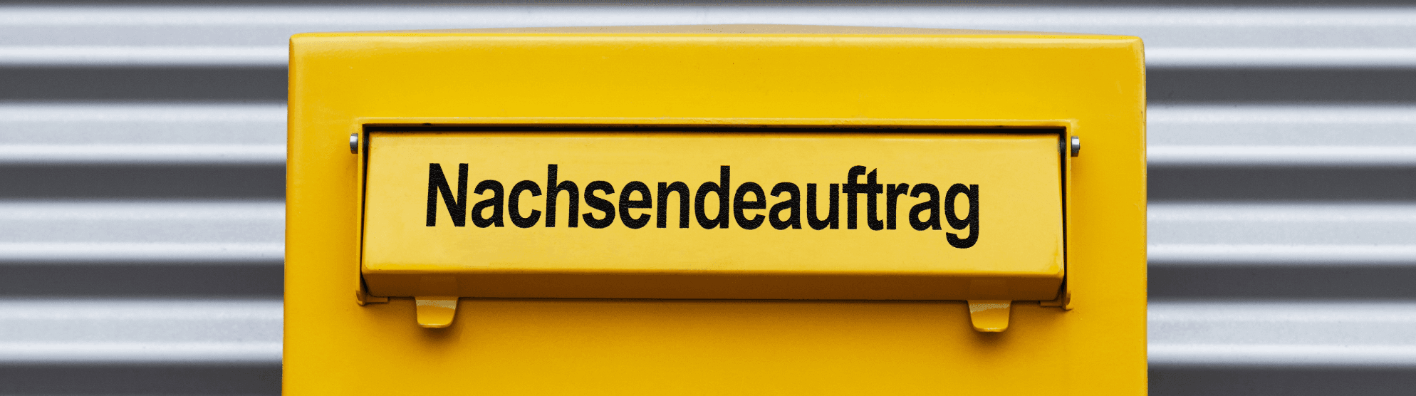 Mailbox with yellow flap labeled "Nachsendeauftrag bei der Post" for mail forwarding during a move.