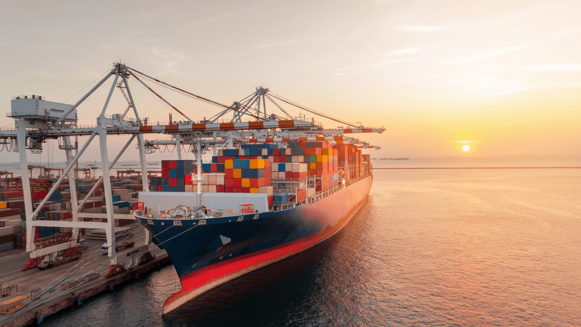 Container ship at discharge port during sunset – symbol for POD (Port of Discharge) in maritime trade.
