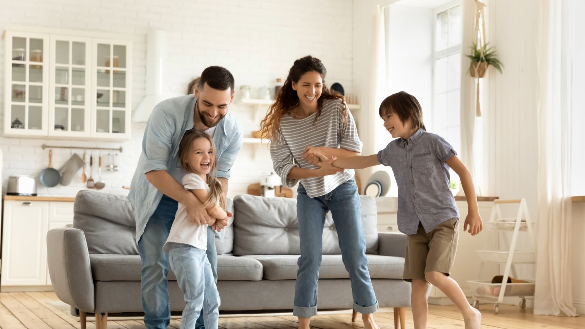 Happy family playing in their new, bright home. Symbolizing a successful move with relocation service for private individuals.