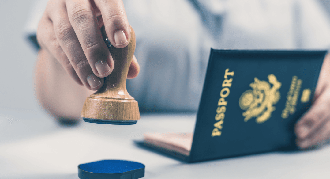 A passport is stamped. Symbolizes the formalities and entry organization at the relocation service for private individuals.