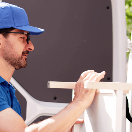 Movers loading furniture into van – ensure proper disposal and recycling during relocation