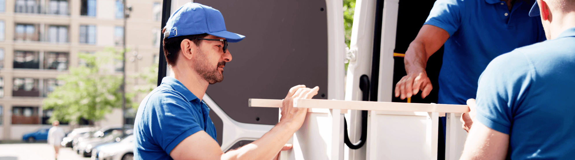 Movers loading furniture into van – ensure proper disposal and recycling during relocation
