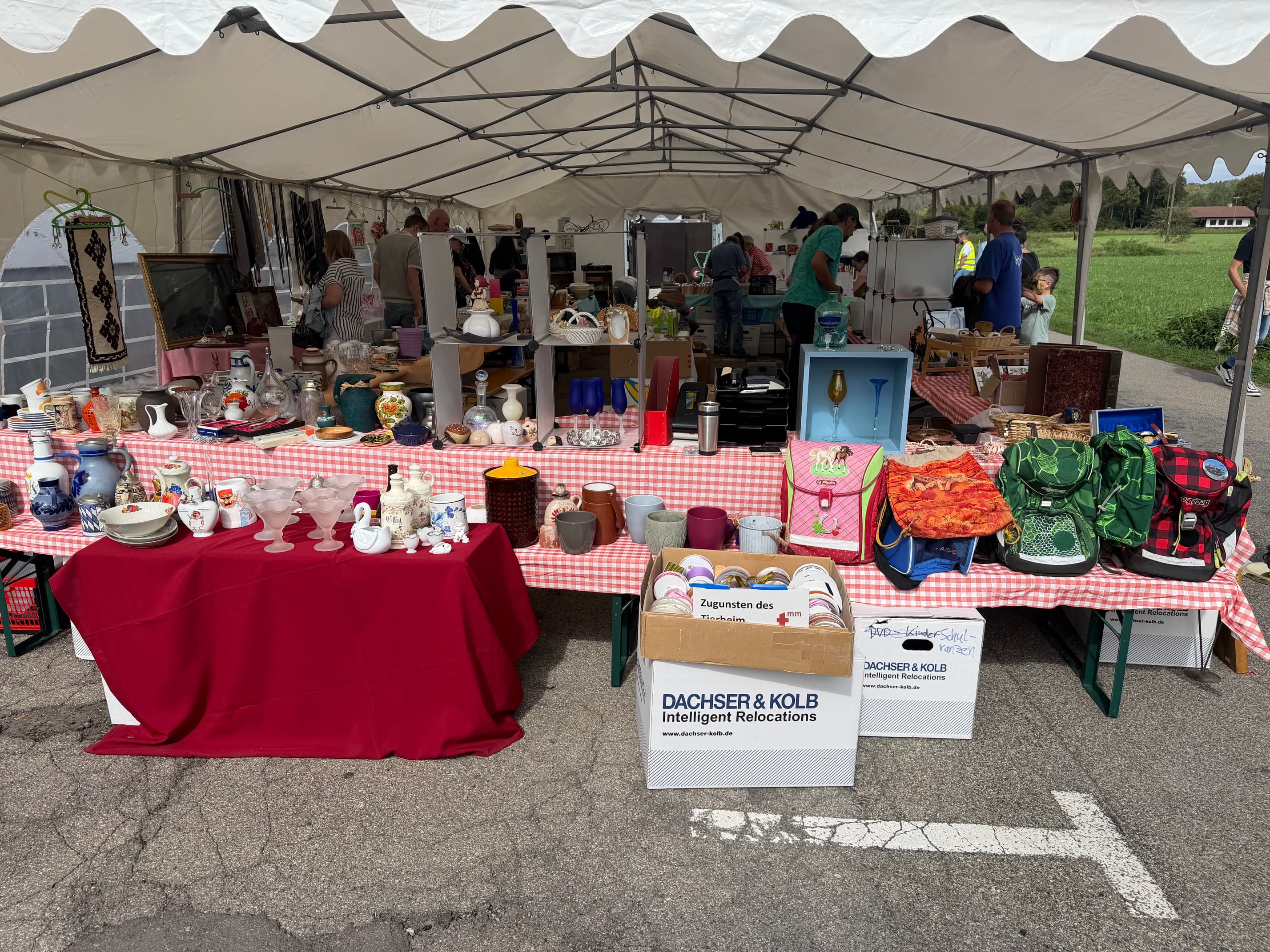 Flea market stall with crockery, bags and moving boxes from DACHSER & KOLB.