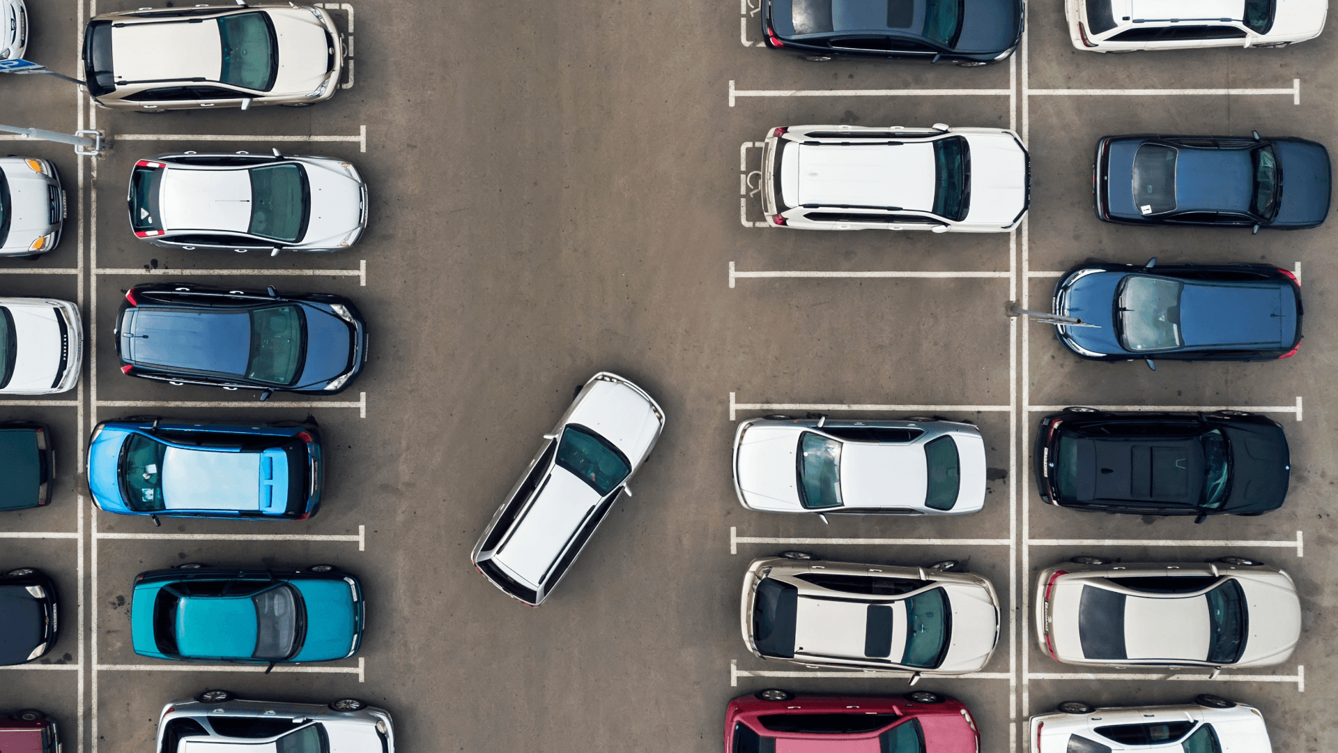 Aerial view of a parking lot with cars – highlights challenges and need to rent a moving van.