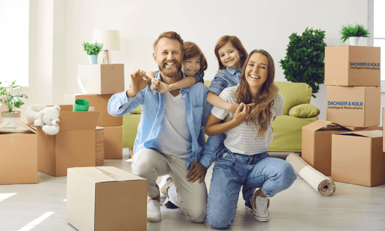 Smiling family posing among moving boxes during VIP relocation for high-profile personalities to a new home