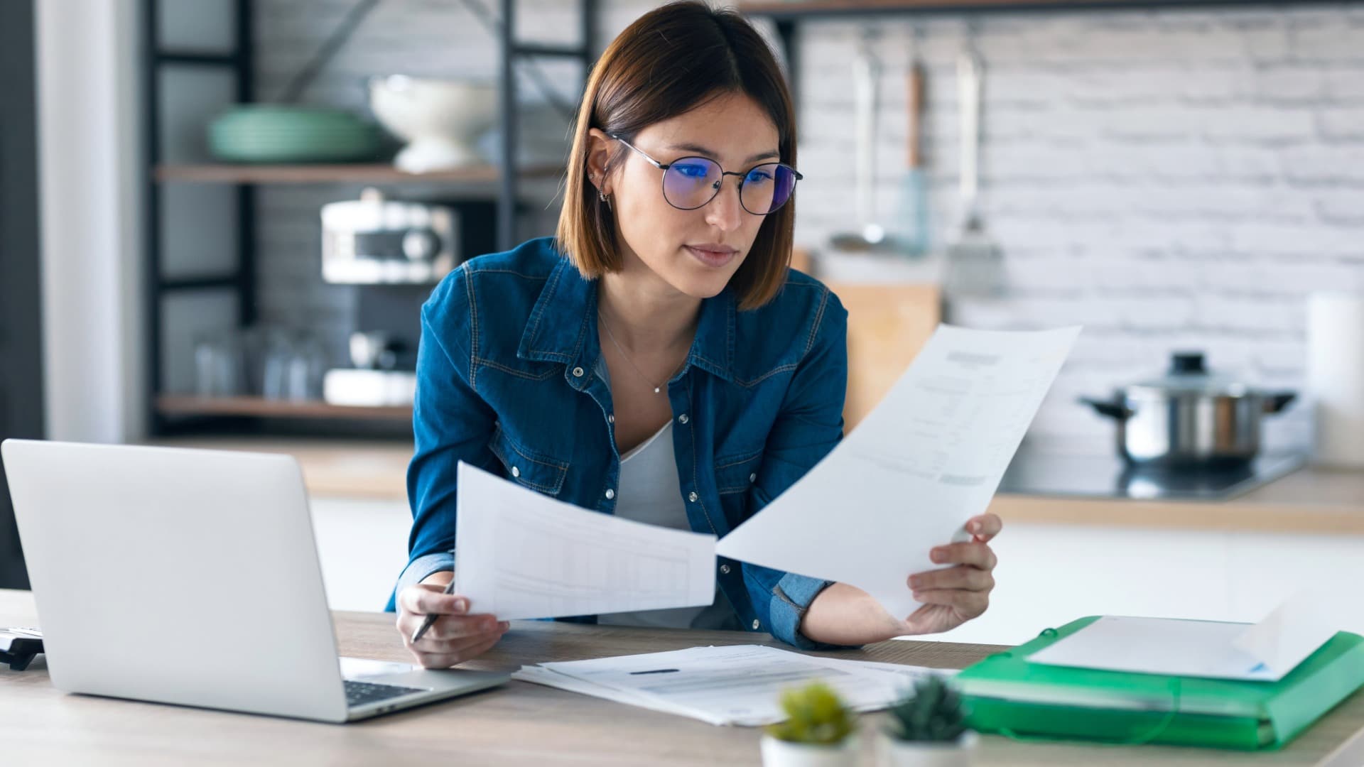 Person reviews documents on a laptop – planning and organizing safe transport in a wine carton