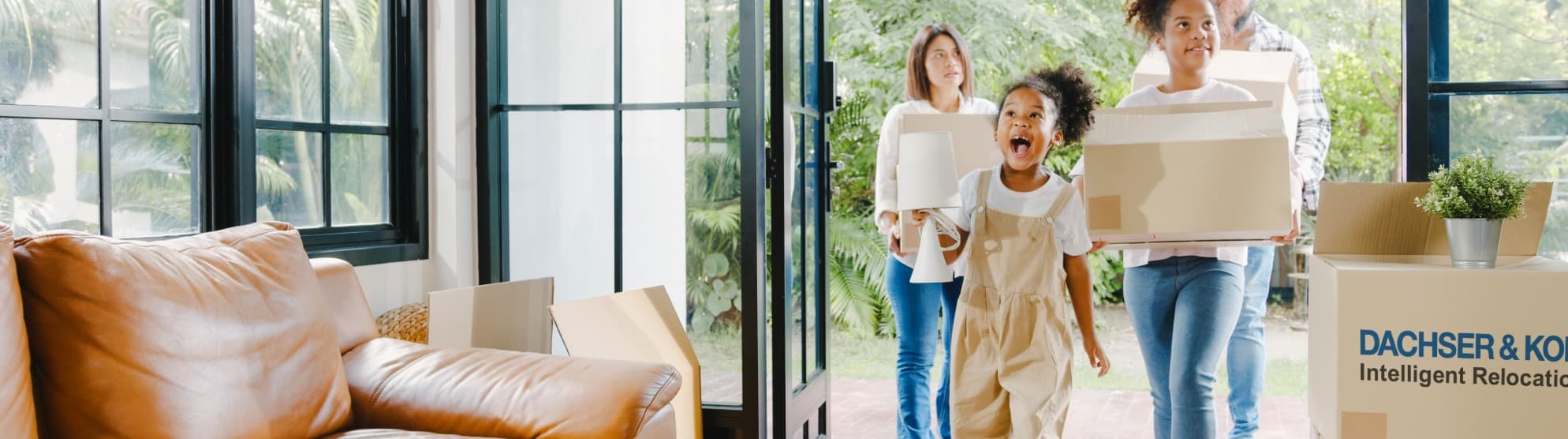Familie trägt Umzugskartons ins neue Zuhause – Symbolbild für praktische Wohntipps