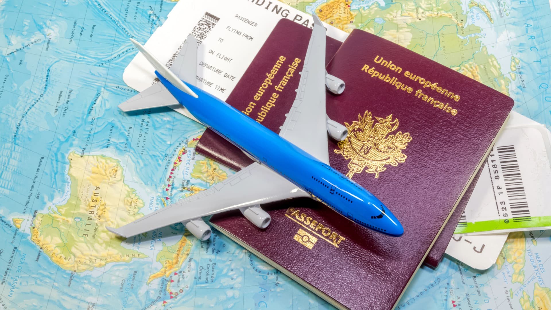 Passports, flight ticket and airplane model on world map for relocation to India